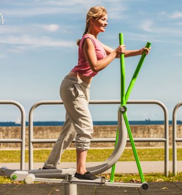 Aktif kadın üzerinde eliptik eğitmen egzersiz.