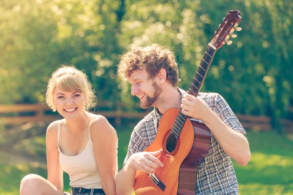 Jovem casal camping tocando guitarra ao ar livre — Fotografia de Stock