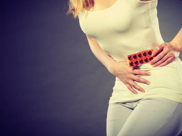 Femme souffrent de douleurs abdominales détient des pilules — Photo