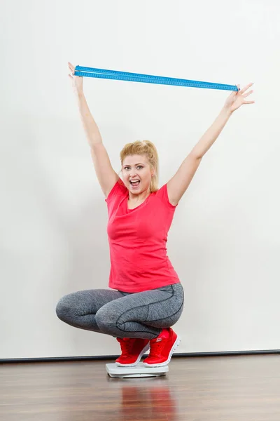 Woman wearing sportswear standing on weight machine — Stock Photo, Image