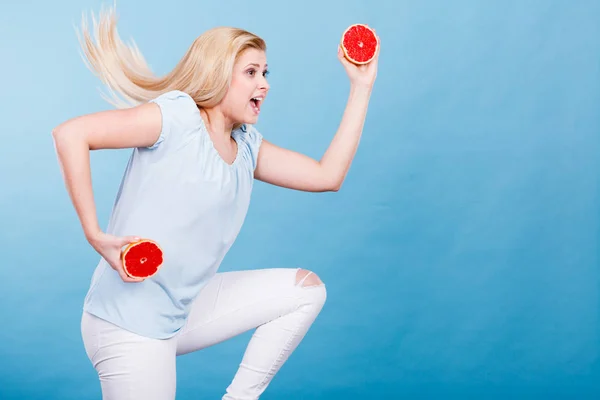 Kvinna anläggning röd grapefrukt — Stockfoto