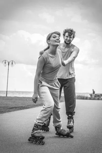 Mulher e homem casal rollerskates ao ar livre — Fotografia de Stock