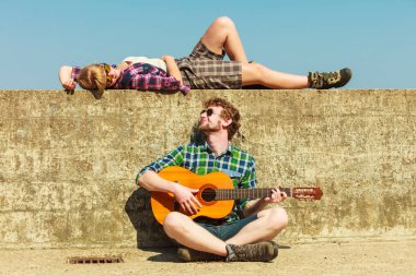 Genç adam onun kız arkadaşı deniz kenarında gitar çalmak