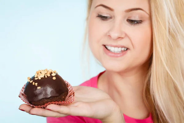 Woman holding chocolate cupcake about to bite — Stock Photo, Image