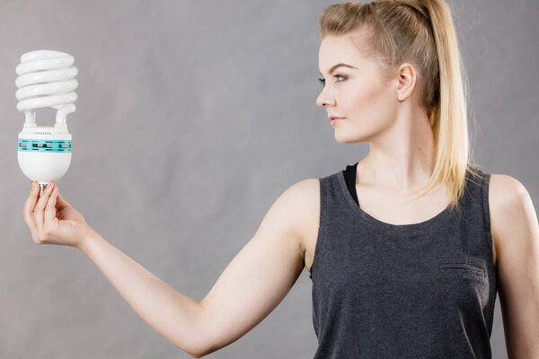 Женщина держит эко-современную лампочку
