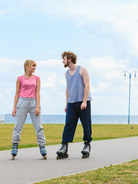 Pareja usando patines mirándose el uno al otro — Foto de Stock