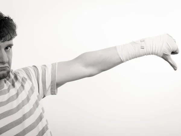 Triste uomo mostrando pollice verso il basso dalla mano fasciata . — Foto Stock