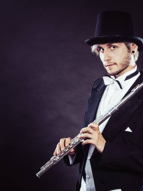 Zarif giyimli müzisyen flüt tutan