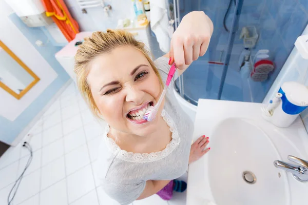 Mulher escovando os dentes de limpeza no banheiro — Fotografia de Stock