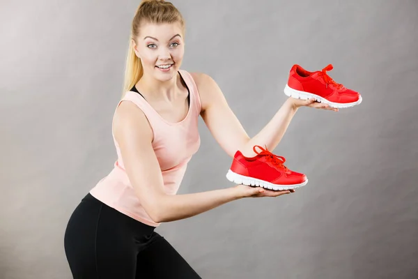 Mujer feliz presentando zapatillas deportivas zapatillas —  Fotos de Stock