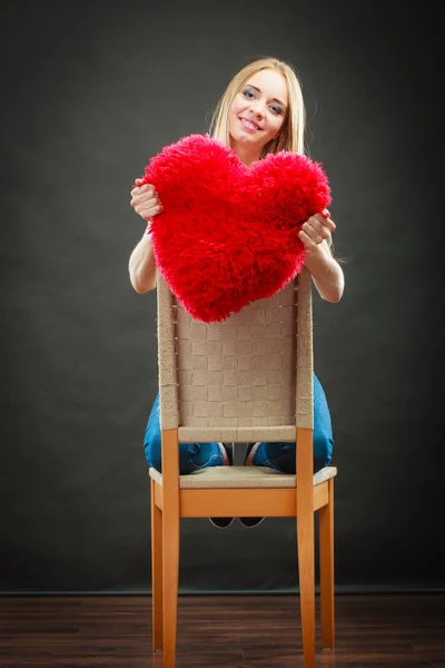 Mujer sosteniendo corazón en forma de almohada símbolo de amor — Foto de Stock