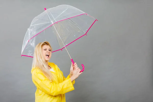 Boldog nő visel gazdaság átlátszó esernyő esőkabát — Stock Fotó