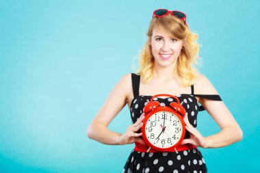 Mavi çalar saat ile gülümseyen kız.