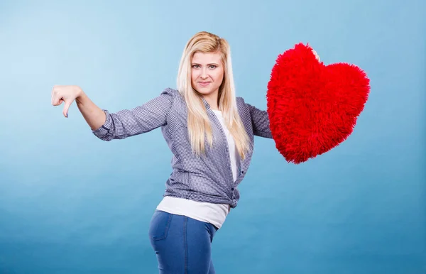 Mujer sosteniendo el corazón rojo mostrando el pulgar hacia abajo — Foto de Stock