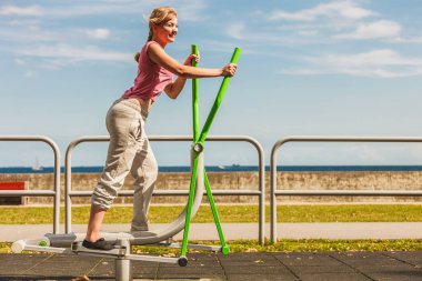 Aktif kadın üzerinde eliptik eğitmen egzersiz.