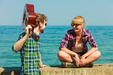 Genç adam onun kız arkadaşı deniz kenarında gitar çalmak