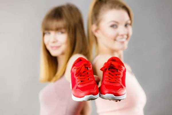 Zwei Frauen präsentieren Sportbekleidung Turnschuhe — Stockfoto