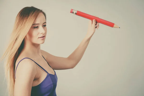 Blonde woman holds big pencil in hand drawing — Stock Photo, Image