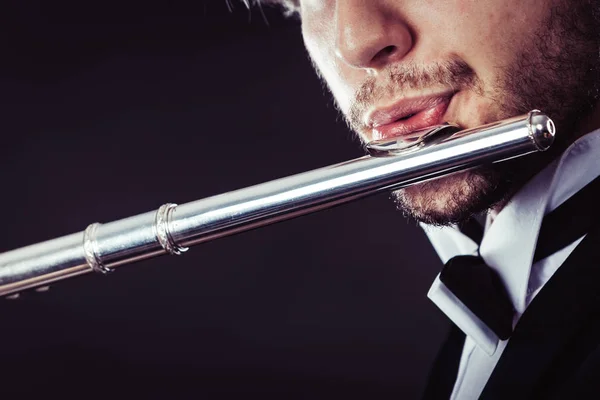 Elegantly dressed male musician playing flute — Stock Photo, Image