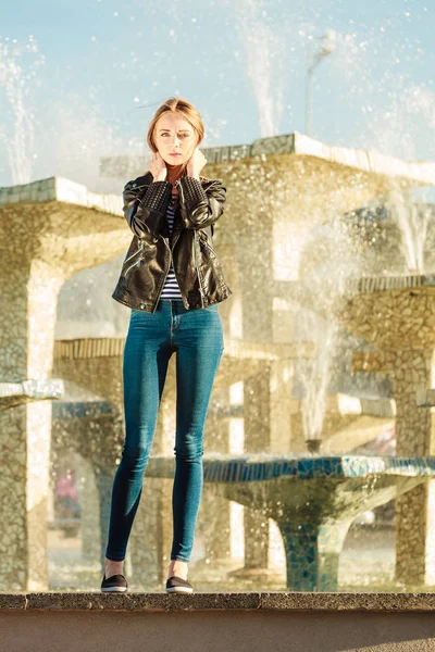 Donna stile casual posa contro fontana della città — Foto Stock