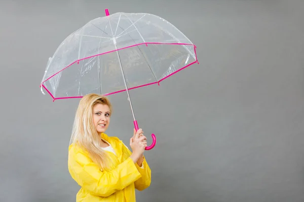 Mujer feliz vistiendo impermeable con paraguas transparente — Foto de Stock