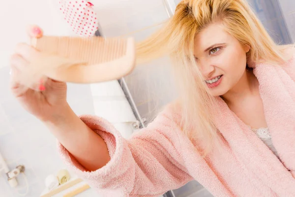 Chockad kvinna iklädd morgonrock borsta håret — Stockfoto
