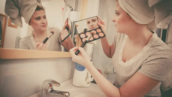 Vrouw in de badkamer toepassen contour bronzer op penseel — Stockfoto