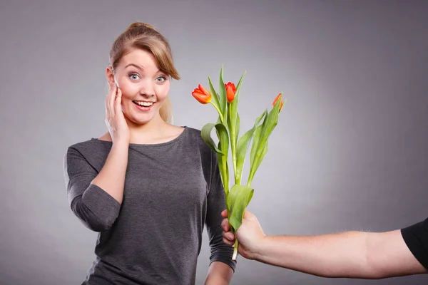 Žena dostane kytici tulipánů od člověka. — Stock fotografie