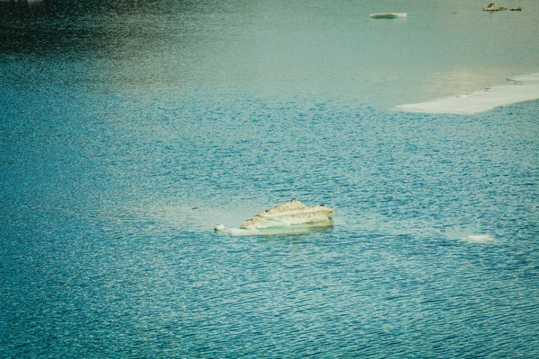 Fragmentos de gelo na água do rio ou do lago, fundo azul — Fotografia de Stock