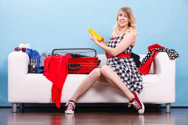 Young woman packing suitcase on couch — Stock Photo, Image