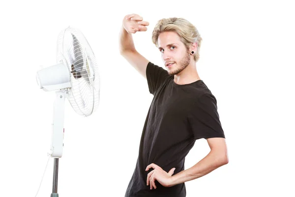 Jeune homme devant le ventilateur de refroidissement — Photo