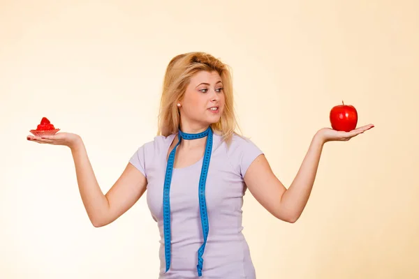 Vrouw kiezen tussen apple en zoete cupcake — Stockfoto