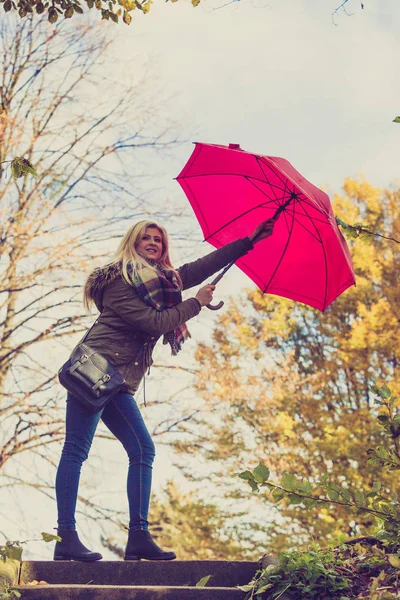 Женщина гуляет в парке с зонтиком, сильный ветер — стоковое фото