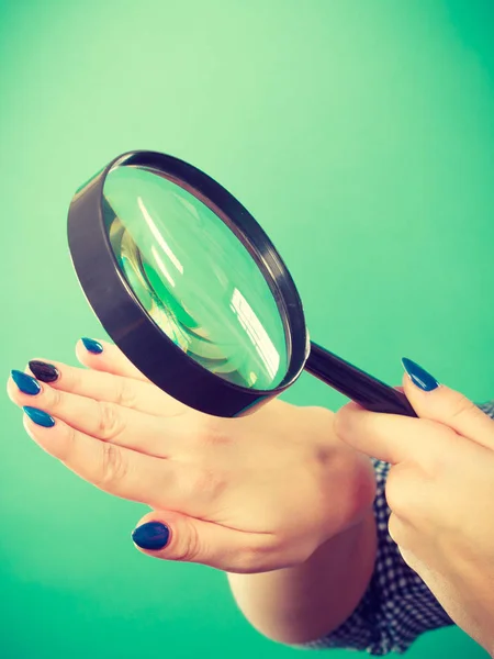 Vrouw op zoek naar nagels door vergrootglas — Stockfoto