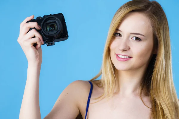Молодая женщина держит старомодный фотоаппарат — стоковое фото