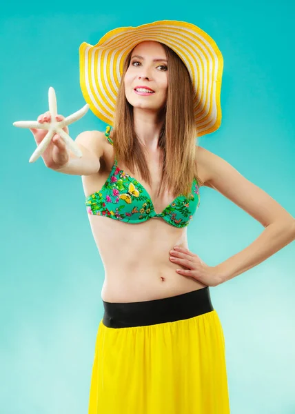 Woman in yellow hat holding white shell — Stock Photo, Image