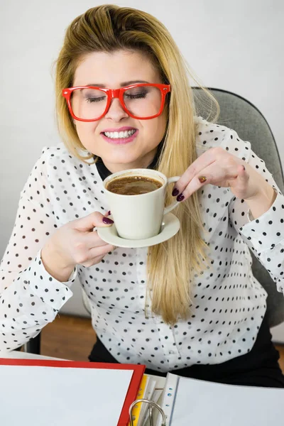 Gelukkige vrouw op kantoor warme koffie drinken — Stockfoto