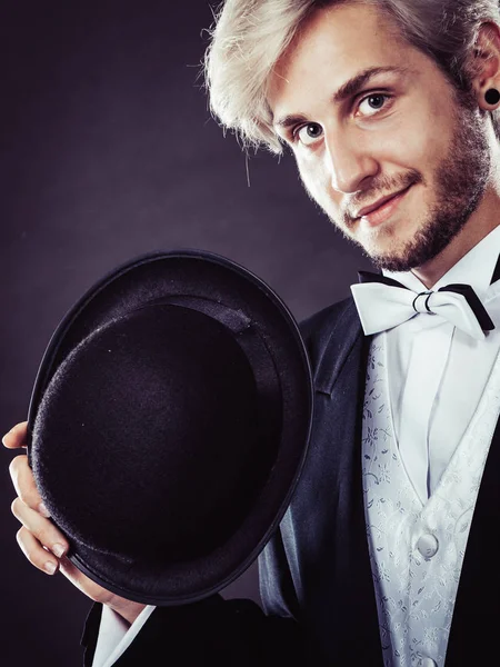 Elegantemente vestido homem segurando chapéu fedora preto — Fotografia de Stock