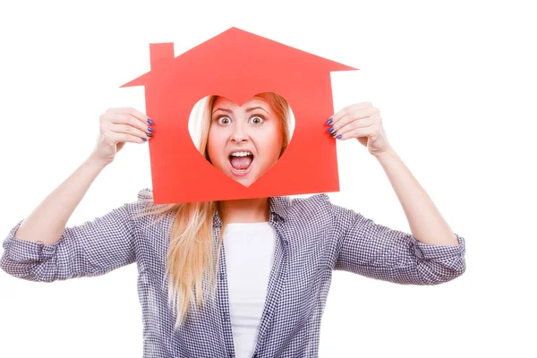 Chica divertida sosteniendo casa de papel rojo con forma de corazón — Foto de Stock