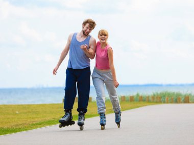 Genç bir çift paten yaparken elele