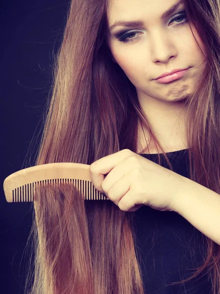 Long haired woman combing her hair. — Stock Photo, Image