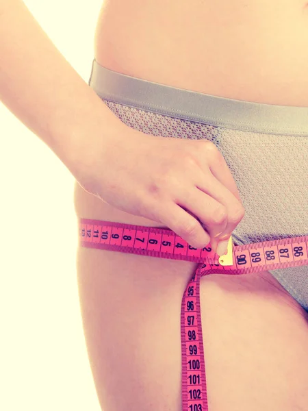 Woman in lingerie measuring her hips with measure tape. — Stock Photo, Image