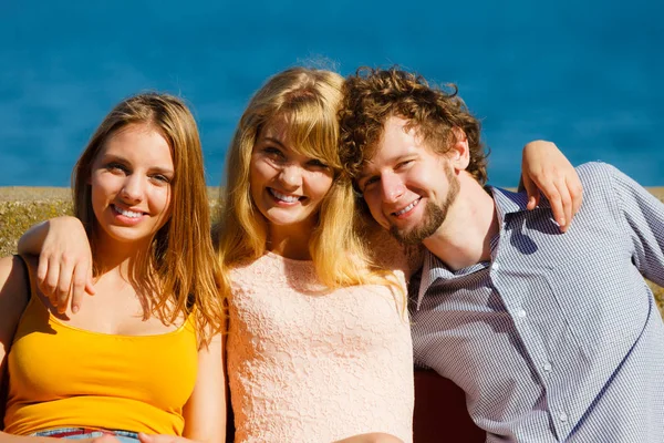 Three happy young people friends outdoor.