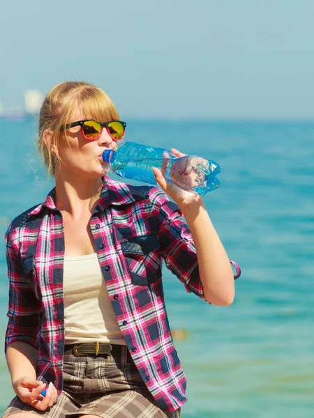 Jonge vrouw drinken van water buiten — Stockfoto