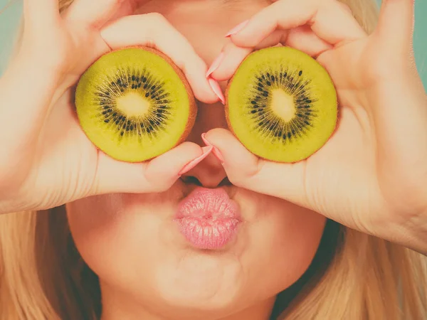 Vrouw met groene kiwi fruit zoals brillen — Stockfoto