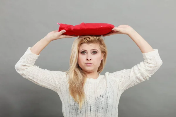 Женщина держит красную бутылку с горячей водой на голове — стоковое фото
