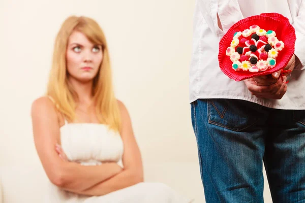 Man met snoep bos bloemen en ongelukkige vrouw. — Stockfoto