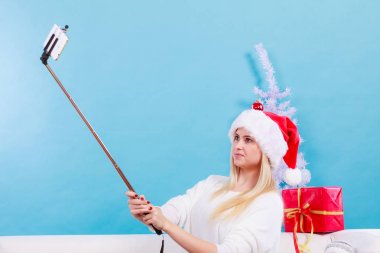 Santa şapka alarak fotoğrafını selfie stick kullanarak kız