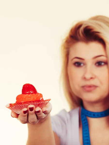 Frau mit Maßband hält süßen Cupcake — Stockfoto