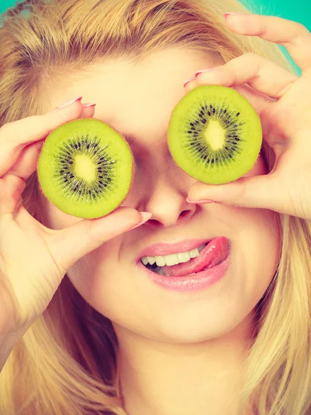 Woman holding green kiwi fruit like eyeglasses — Stock Photo, Image